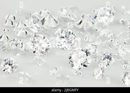 Diamantfoto mit Nahaufnahme mit verschiedenen Diamanten auf grauem Hintergrund. Stockfoto