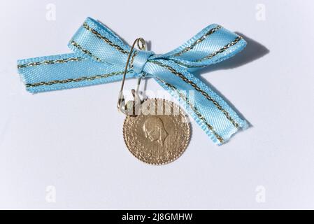 Türkische Viertel Goldmünze mit blauem Band auf einem isolierten Hintergrund, Makrofotografie, Wirtschaft Stockfoto