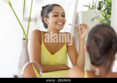 Glückliche Frau, die ihre Zähne putzen Stockfoto