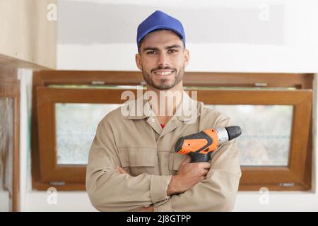 Porträt eines jungen Handwerkers mit einer Akku-Bohrmaschine Stockfoto