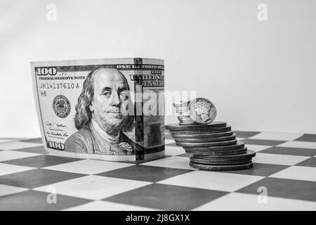 Amerikanisches Geld, US-Währung, 100-Dollar-Bill, Stapel Silbermünzen, Mercury Dime, im Schachbrett Stockfoto