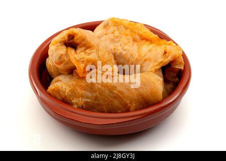 Traditionelle Balkan-Food-Rezept-Konzept mit Kohlröllchen gefüllt mit Fleisch (Türkisch: Sarma, Rumänisch: Sarmale) in braunen Töpferschale isoliert auf whit Stockfoto