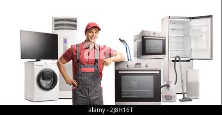 Ein Reparaturmann in Uniform steht neben einem elektrischen Ofen und andere Geräte auf weißem Hintergrund isoliert Stockfoto