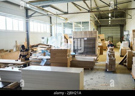 Manuelle Arbeiter, die mit Fracht in Kartons im Distributionslager für den weiteren Export arbeiten Stockfoto