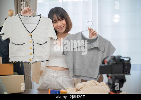Junge Frau arbeitet live Streaming Online-Bekleidungsgeschäft zu Hause. Stockfoto