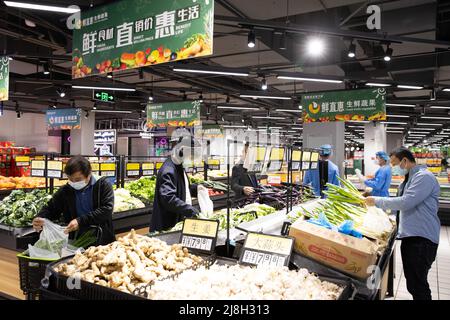 Shanghai. 16.. Mai 2022. Menschen kaufen in einem Supermarkt im Xuhui Bezirk im ostchinesischen Shanghai ein, 16. Mai 2022. Das chinesische Shanghai hat die Übertragung von COVID-19 in 15 von 16 Bezirken der Gemeinschaft abgeschnitten, so eine Pressekonferenz über die Prävention und Kontrolle von Epidemien, die am Montag stattfand. Quelle: Jin Liwang/Xinhua/Alamy Live News Stockfoto