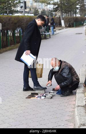 Ulaanbaatar, Mongolei - 11. Mai 2022: mongolischer Mann verdient Geld mit Putzschuhen. Stockfoto