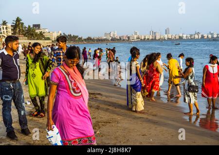 Mumbai, Maharashtra, Indien : die Menschen entspannen sich am Girgaon Chowpatty Strand. Schiffsfahrt und Nariman Point im Hintergrund. Stockfoto