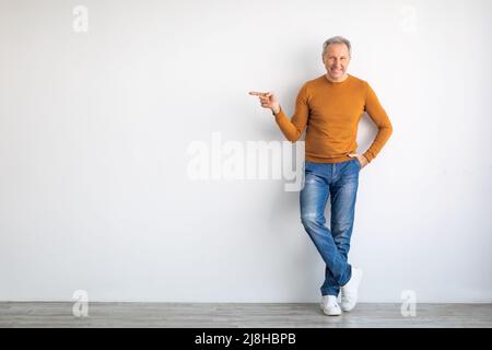 Aufgeregter Senior zeigt auf freien Kopierplatz Stockfoto