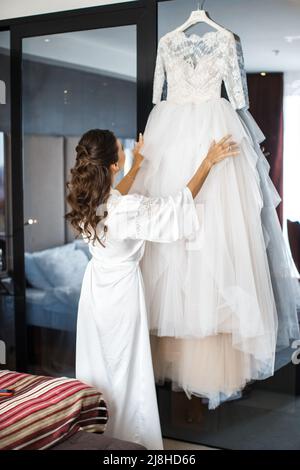 Die Braut mit Hochzeitskleid im Hotelzimmer Stockfoto