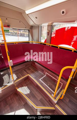 Hamburg, Deutschland. 16.. Mai 2022. Blick auf eine über die Ecke angeordnete Sitzbank mit durchgehender Sitzfläche im hinteren Bereich eines der neuen E-Busse der Verkehrsbetriebe Hamburg-Holstein (VHH). VHH präsentierte ein neues Innenraumkonzept für die Volvo E-Gelenkbusse. Quelle: Georg Wendt/dpa/Alamy Live News Stockfoto