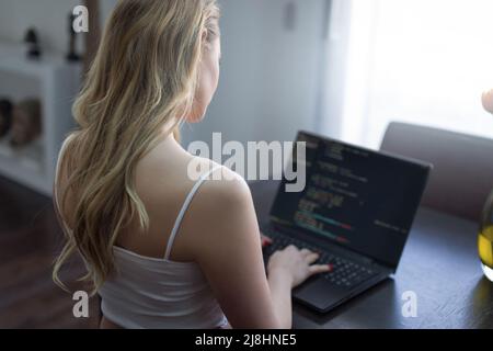 Junge blonde Frau Programmierer Codierung auf Laptop zu Hause Stockfoto