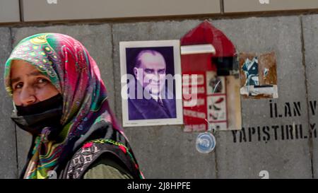 Izmir, Türkei. 15/05/2022, Casual Menschen sind zu Fuß und vorbei vor einem Spiegel mit Spiegelung einer türkischen Flagge und Atatürks Plakat an der Wand auf der Straße im täglichen Leben von Izmir, Türkei. Stockfoto