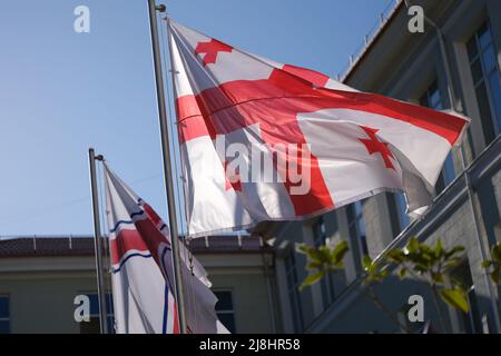 Nationalflagge Georgiens winkt im Wind auf blauem Himmel Hintergrund Stockfoto