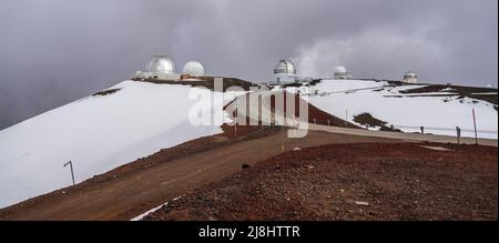 Unbefestigte Straße auf dem Gipfel des Mauna Kea Vulkans auf der Big Island von Hawaii führt zu mehreren internationalen Observatorien für astronomische Forschung Stockfoto