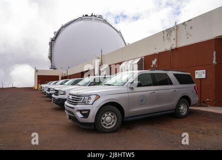 Vor dem Keck Observatory auf dem Gipfel des Vulkans Mauna Kea auf der Big Island von Hawaii, USA, parkten Forschungs-Lastwagen Stockfoto