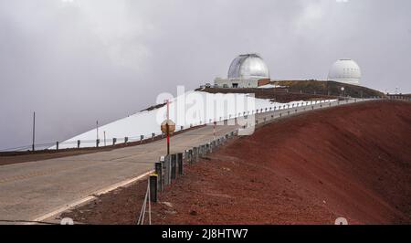 Unbefestigte Straße auf dem Gipfel des Mauna Kea Vulkans auf der Big Island von Hawaii führt zu mehreren internationalen Observatorien für astronomische Forschung Stockfoto