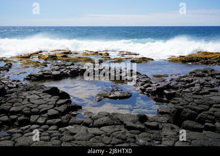 Gezeitenpools auf säulenförmigen, vulkanischen Lavagestein im South Point Park, dem südlichsten Punkt der Vereinigten Staaten auf der Big Island von Hawaii in der Stockfoto