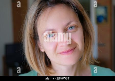 Lächelnde Frau mittleren Alters, die glücklich auf die Kamera schaut Stockfoto