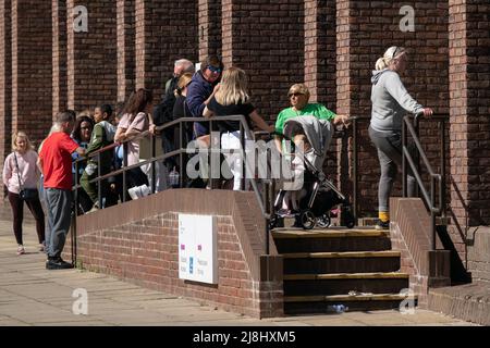 Menschen, die vor dem Passbüro in Peterborough Schlange stehen, da Tausende von Briten aufgrund einer Kombination aus Personalmangel und einem Anstieg der Reisen nach Covid mit der Aussicht auf längere Verzögerungen bei der Beantragung von Passdokumentationen konfrontiert sind. Bilddatum: Montag, 16. Mai 2022. Stockfoto