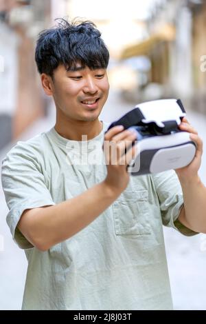 Überrascht Asian mit seiner Virtual-Reality-Brille Stockfoto