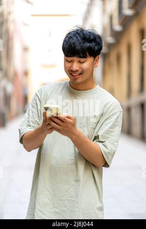 Happy Asian mit seinem neuen Smartphone Stockfoto