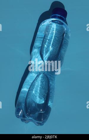 Flasche kaltes Wasser auf blauem Hintergrund Stockfoto