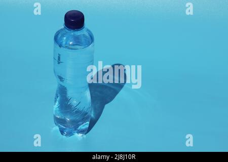 Flasche kaltes Wasser auf blauem Hintergrund Stockfoto