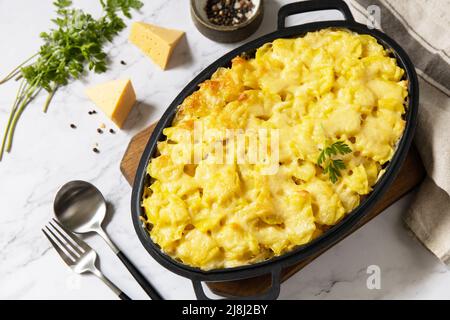 Kartoffelgratin, französische Küche. Gesunder Auflauf oder Gratin mit Creme, Gratin Dauphinois auf einem grauen Steintisch. Stockfoto