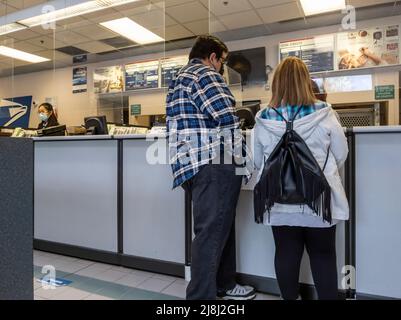 Mill Creek, WA USA - ca. Mai 2022: Schräge Ansicht von Leuten, die Pakete in einem Postamt verschicken. Stockfoto