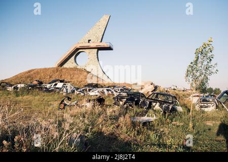 Schrottplatz, Autodumpe, Metallschrott. Ein Haufen beschädigter, zerbrochener, rostiger Autos wuchs mit Gras in der Nähe des größten Sees des kaukasus, Sevan, in den Vororten von Stockfoto