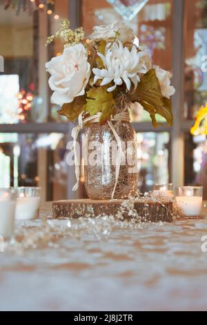 Stillleben Tischdekoration, Kleines Herzstück, Blumen, Twinkle Lights, Kerzen Stockfoto