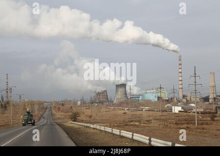 Wolkiger Herbstmorgen in der nordkasachischen Industriestadt Pavlodar. Von den Rohrleitungen und Kühlstationen des Wärmekraftwerks steigt dichter Rauch auf. Stockfoto