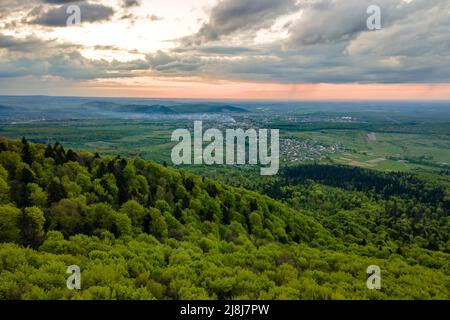 Luftaufnahme der dunklen Berge mit grünen gemischten Kiefern und üppigem Wald am Abend bedeckt Stockfoto