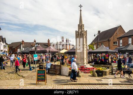 Menschen auf dem Bauern- und Makermarkt rund um den gepflasterten Marktplatz der Marktstadt Sandbach in England Stockfoto