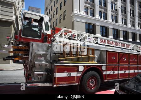 Ein Deichselfeuerwagen mit Lenkrädern vorne und hinten fährt in San Francisco, Kalifornien, entlang einer Straße. Im Heck sitzt ein Bodenbearbeitungsmann. Stockfoto