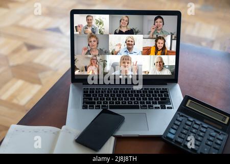 Webcam mit Laptop-Bildschirm zeigt verschiedene ethnische Zugehörigkeit und Alter an, die an der Gruppenvideowand beteiligt sind. Videokonferenz. Moderne Technologie, einfach bequem online Stockfoto