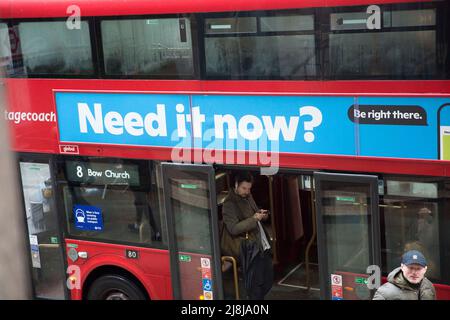 Passagiere, einige tragen eine Maske, andere nicht, werden in einem Doppeldeckerbus in der City of London gesehen. Stockfoto