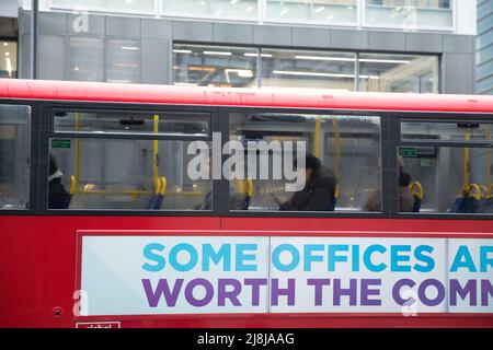 Passagiere, einige tragen eine Maske, andere nicht, werden in einem Doppeldeckerbus in der City of London gesehen. Stockfoto