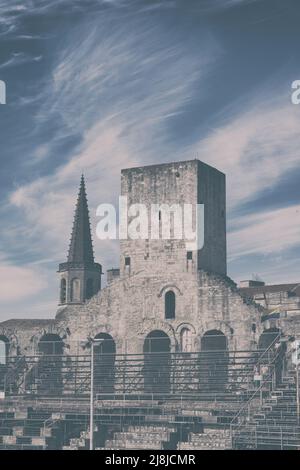 Arles Amphitheater (erbaut 90 n. Chr.). Die Türme auf der Spitze sind mittelalterliche Extras. Im Hintergrund der Glockenturm von Église Couvent des Cordeliers. Arles. Stockfoto