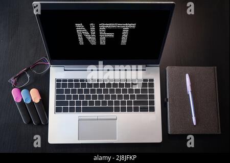 Draufsicht auf Laptop mit Text-NFT. Nicht fungibler Token. Stockfoto