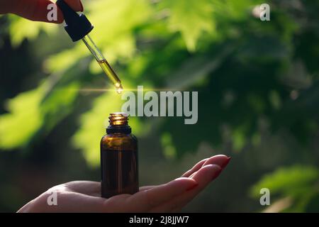 Ätherisches Öl, das aus der Glastropfer fällt. Alternative Medizin, konzeptuelles Image. Speicherplatz kopieren. Stockfoto