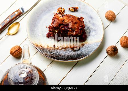 Stück Pie mit Schokolade, Kirschen und Nüssen. Süßer Marmorkuchen. Schokoladenkuchen und Tee Stockfoto
