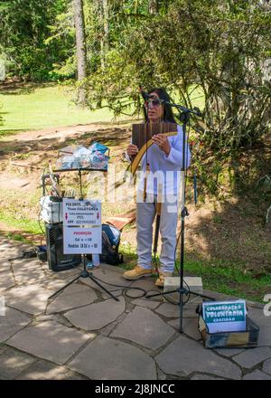 Gramado, Brasilien - ca. April 2022: Gebürtige Amerikanerin spielt die Panflöte am Schwarzen See in Gramado Stockfoto