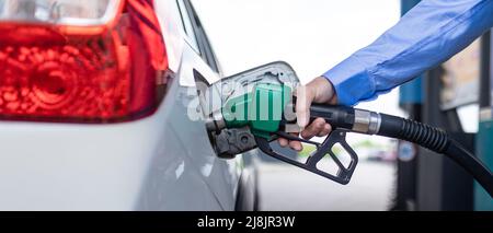 Das Fahrzeug an der Tankstelle von Hand mit Kraftstoff befüllen Stockfoto