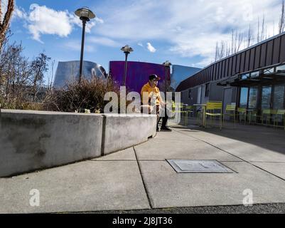 Seattle, WA USA - ca. April 2022: Blick auf einen Mann, der mit seinen zwei Hunden draußen in der Nähe des Seattle Center-Bereichs herumhing. Stockfoto