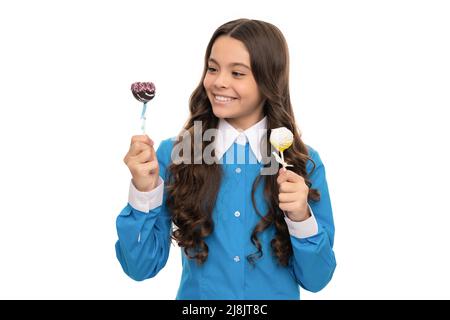 Glückliches Kind mit Schokolade. Kind mit langen lockigen Haaren halten Stick süß. Zucker Süßigkeiten auf Stick Stockfoto