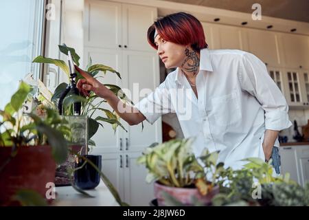 Asian Kerl mit Smartphone auf einem Stativ, um ein Video zu Hause zu erstellen Stockfoto