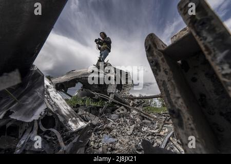 Charkiw, Ukraine. 16.. Mai 2022. Ein Videofilmer filmt am Montag, den 16. Mai 2022, einen Mi-28-Hubschrauber, der Anfang März auf einem Feld östlich von Charkiw in Biskvitne, Ukraine, abstürzte. Ukrainische Streitkräfte sagten am Montag, dass ihre Gegenoffensive in der zweitgrößten Stadt Charkiw es ihnen ermöglicht hat, russische Streitkräfte in einem der größten Rückschläge für Moskau seit Beginn der Invasion zurückzudrängen. Foto von Ken Cedeno/UPI Credit: UPI/Alamy Live News Stockfoto