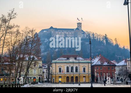 LJUBLJANA, SLOWENIEN - 15. FEBRUAR 2022: Akademische Philharmonie auf dem Kongressplatz und die Burg im Hintergrund Stockfoto